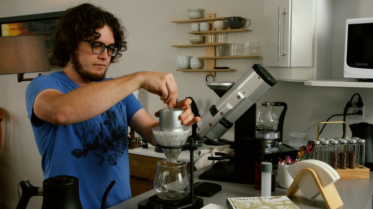Jonathan Gagné est en train de préparer un café dans sa cuisine.