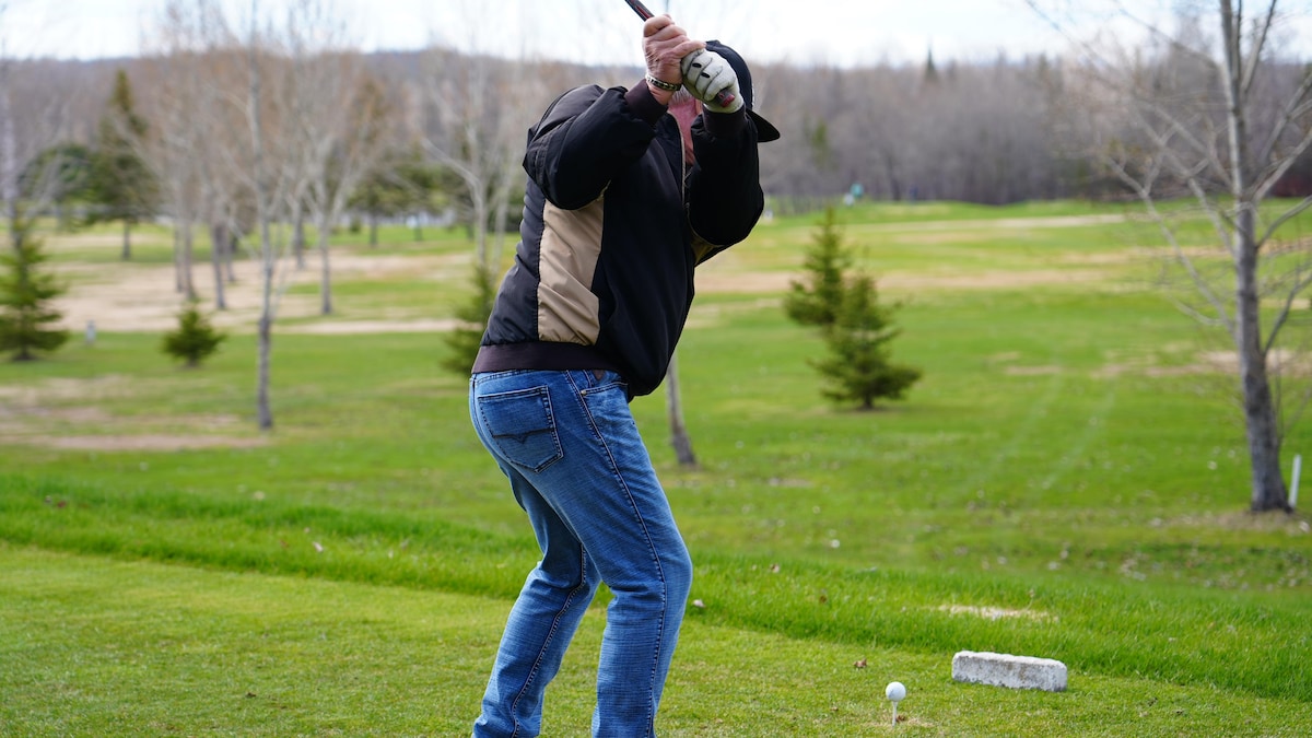 Un homme s'apprête à frapper une balle de golf.  