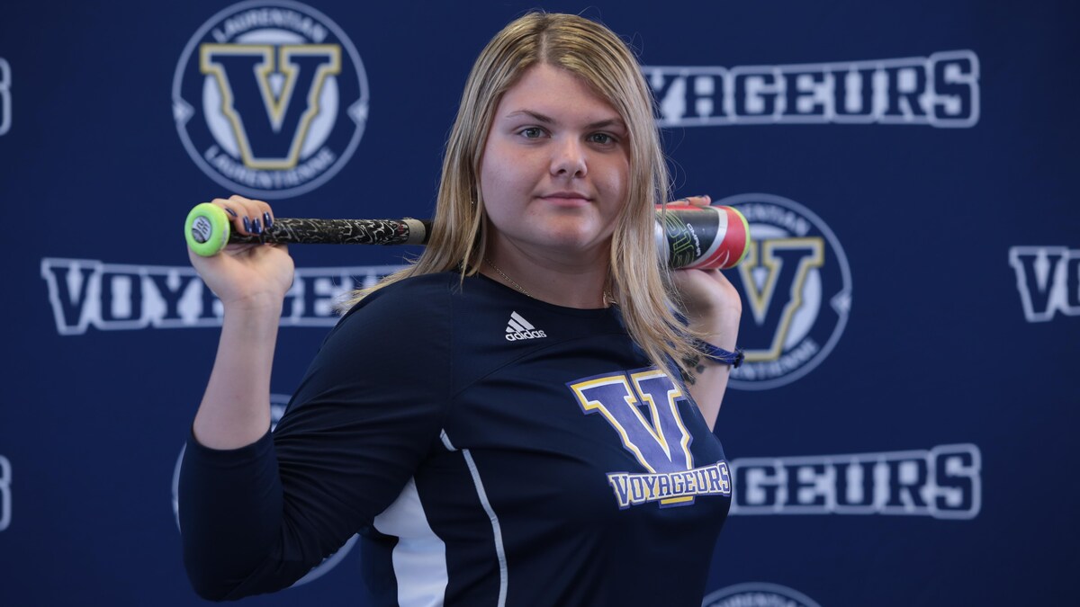 Julia Jodouin tient un bâton de baseball derrière son cou.