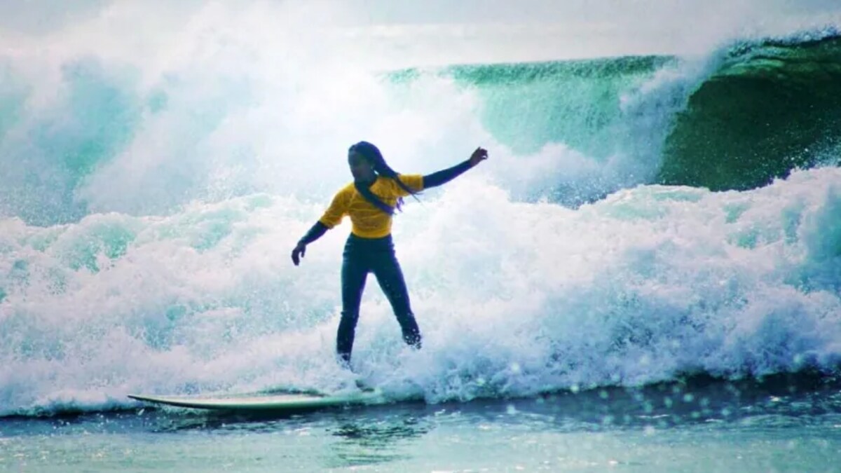 La jeune surfeuse debut sur une vague.