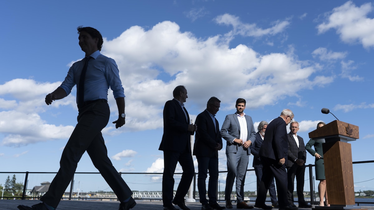 Le premier ministre Justin Trudeau s'éloigne après une annonce faite en août sous les yeux d'autres députés lors d'une conférence de presse à Charlottetown, à l'Île-du-Prince-Édouard.