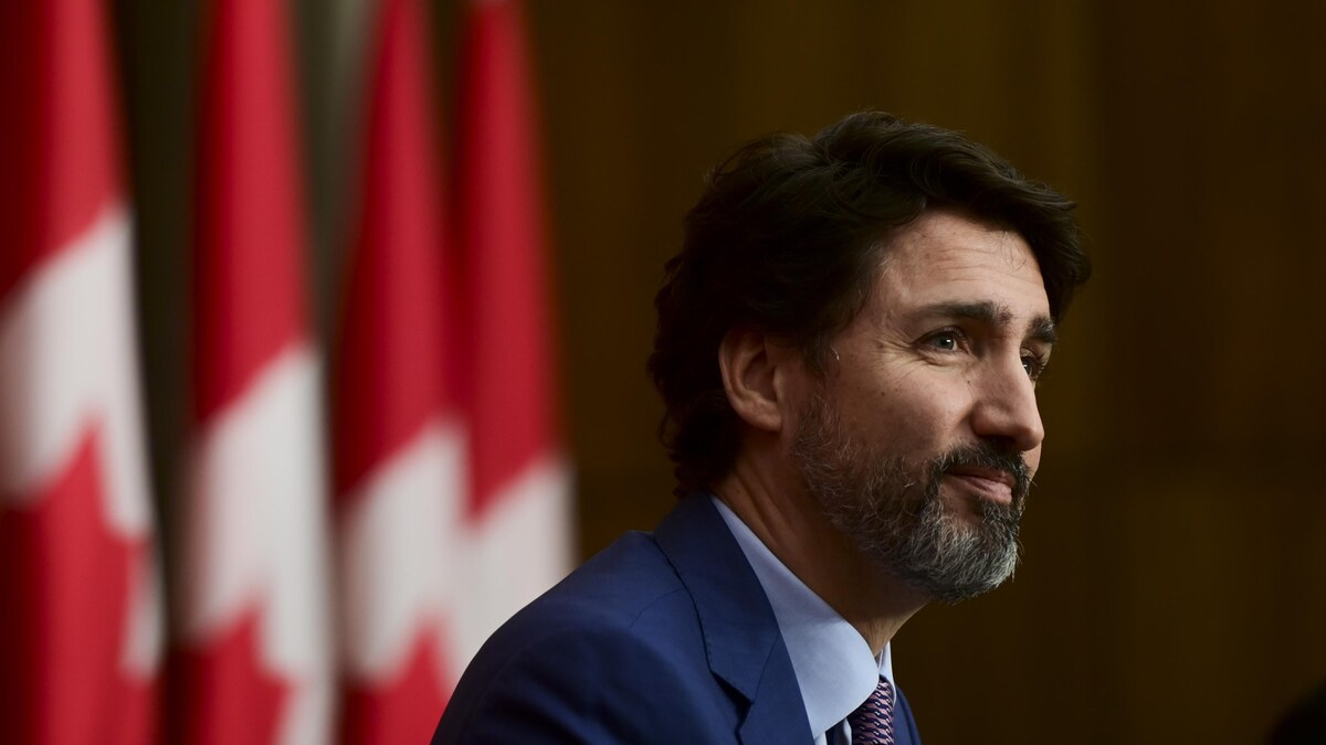 Le premier ministre du Canada Justin Trudeau assis durant une conférence de presse..