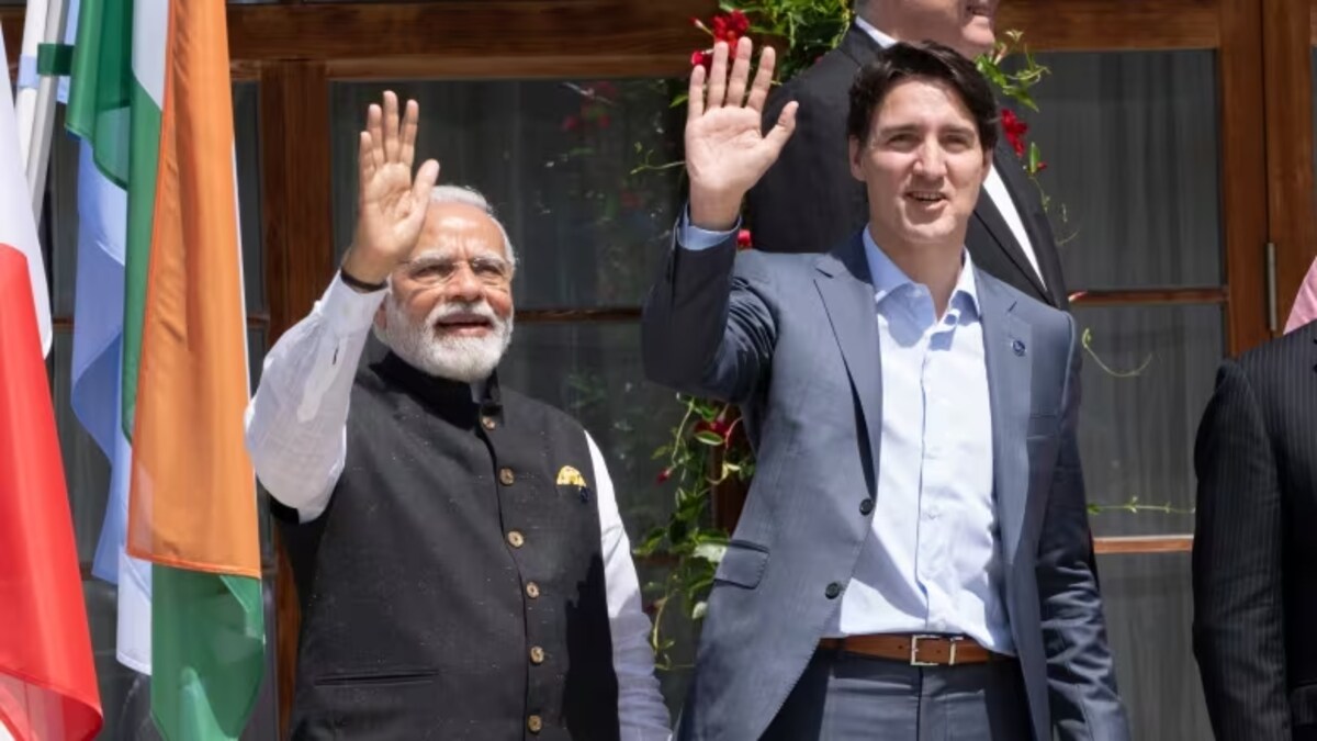 Narendra Modi et Justin Trudeau saluent la foule de la main.
