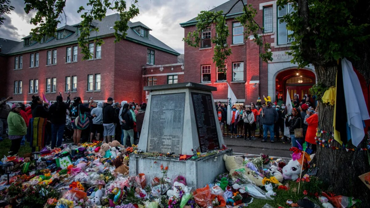 Des personnes réunies autour d'un mémorial et de peluches à Kamloops.