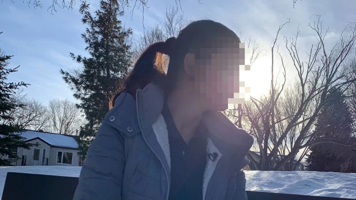 Une personne assise sur un banc de parc, avec son visage flouté.