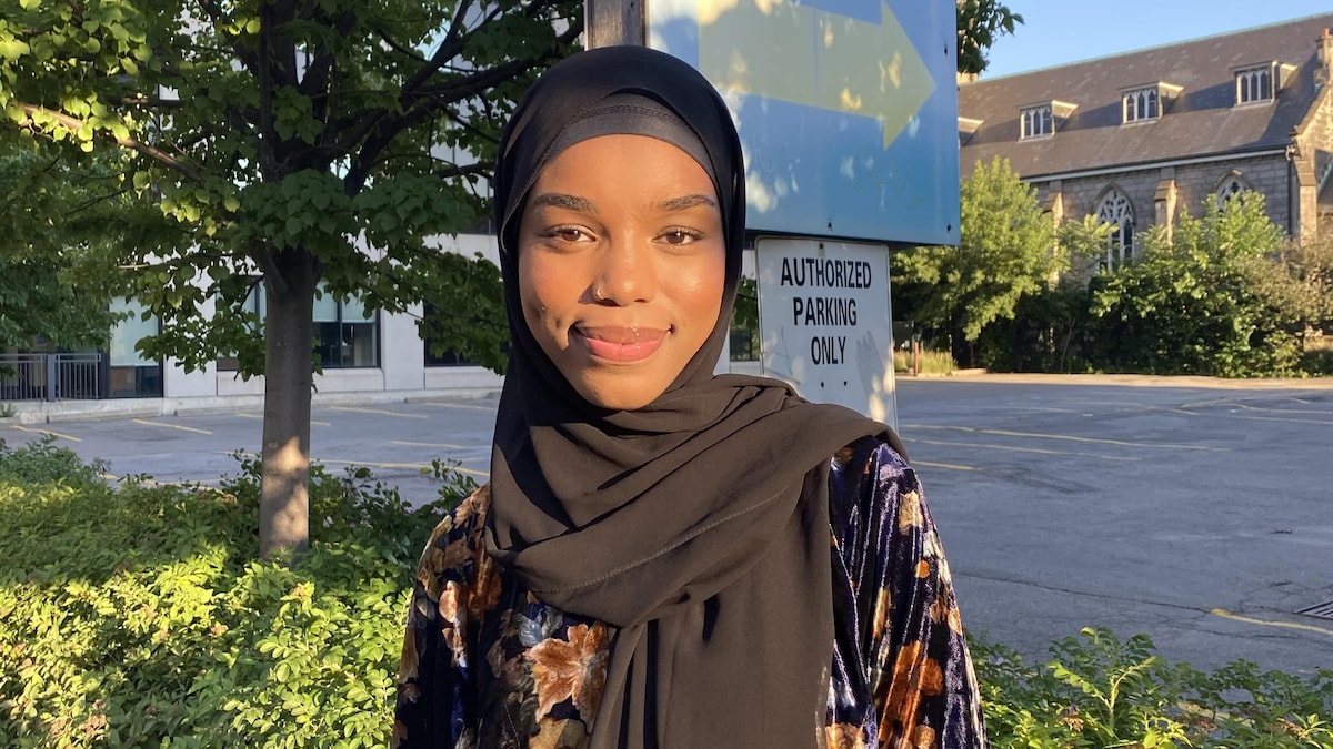 Une jeune femme se tient debout dans la rue