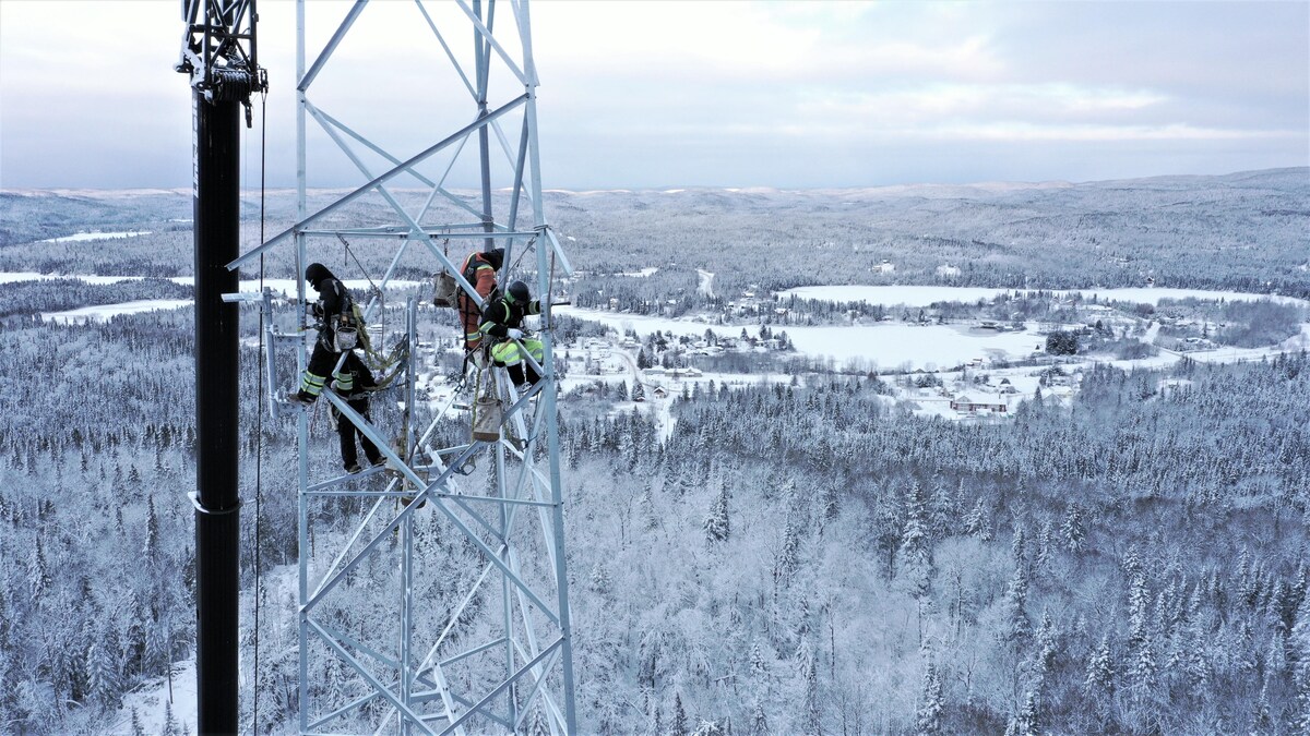 Des travailleurs dans la tour de communications, dans le paysage enneigé de Lac-Édouard.