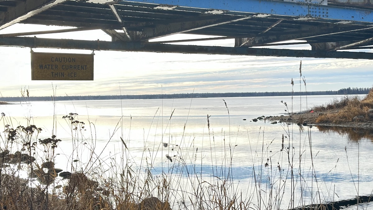 Le lac, un pont et une pancarte signalant la qualité de la glace.