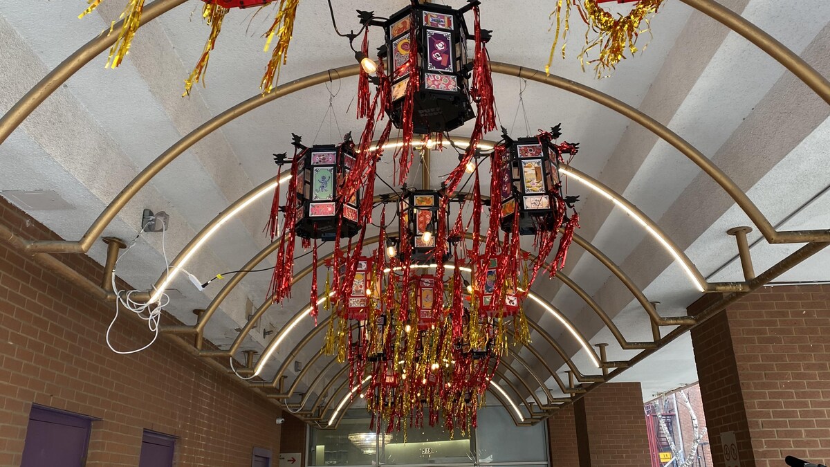 Des lanternes colorées sont fixées à un plafond.