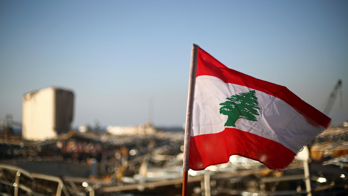 Le drapeau libanais flotte près de ruines dans le port.
