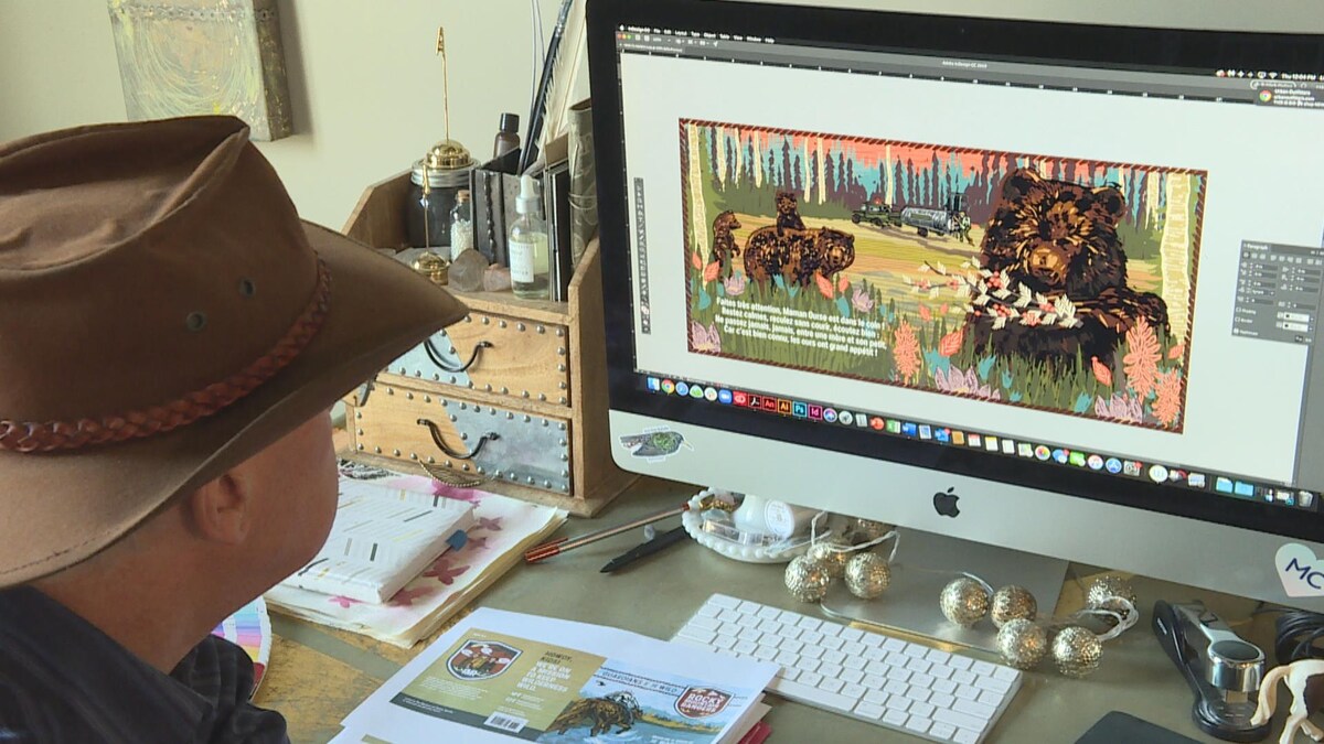 Un homme est assis, de dos, devant un bureau avec un écran d'ordinateur dessus.
Il porte un chapeau cowboy. L'écran montre une illustration colorée d'ours.