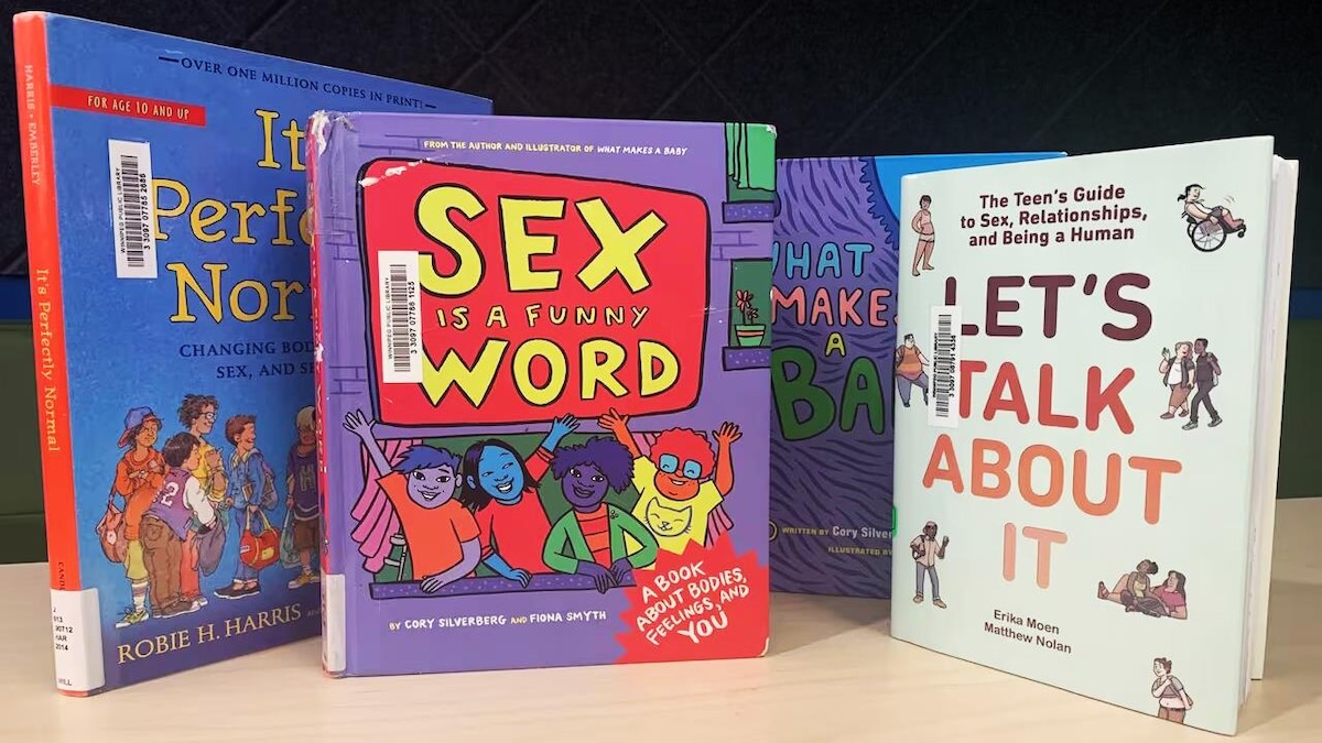 Quatre livres pour enfants au sujet de la sexualité sont posés sur une table.