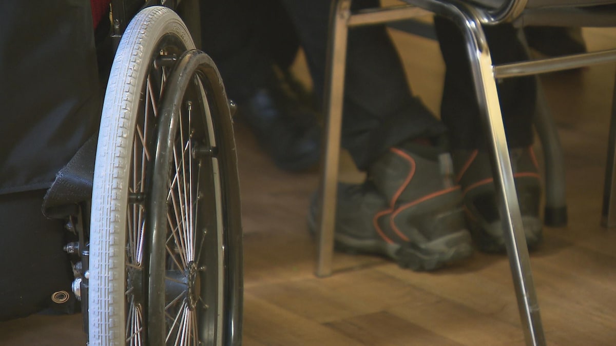 Les roues d'une chaise roulante à côté des pattes d'une chaise. 