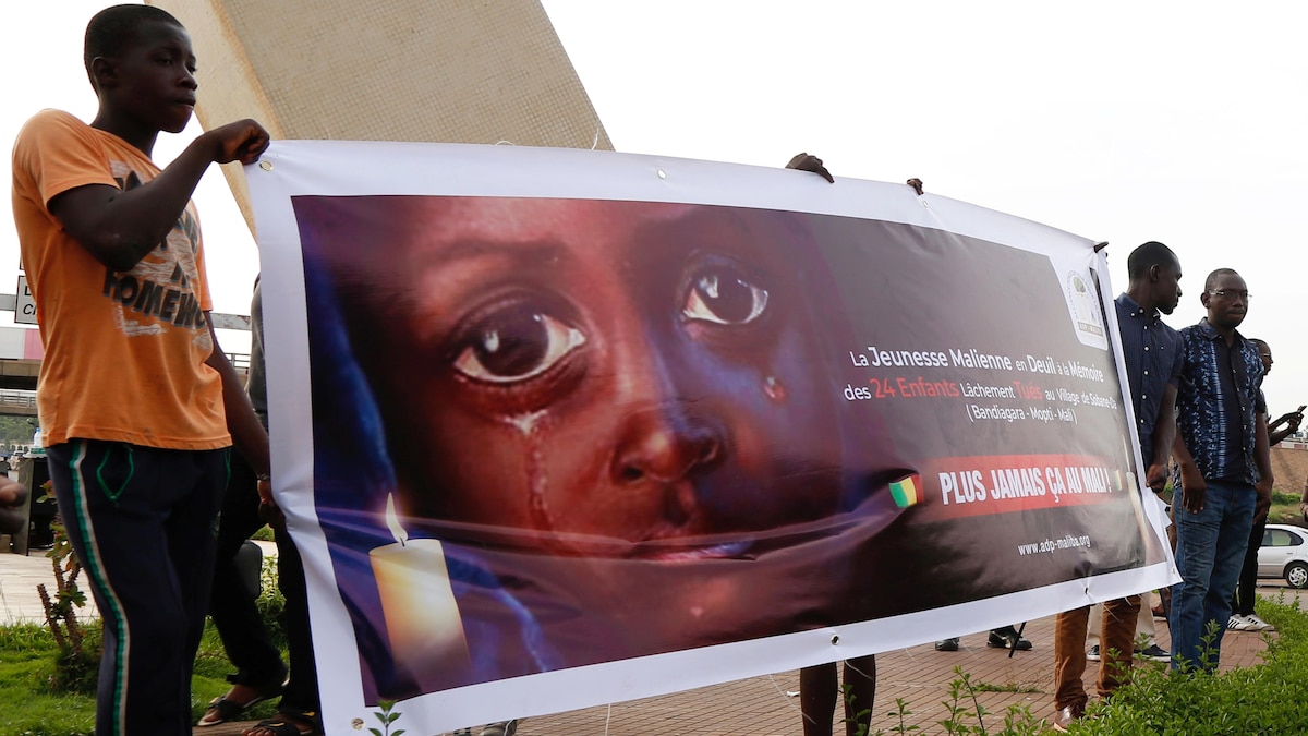 Des personnes brandissent une affiche avec le slogan : « Plus jamais ça au Mali! »