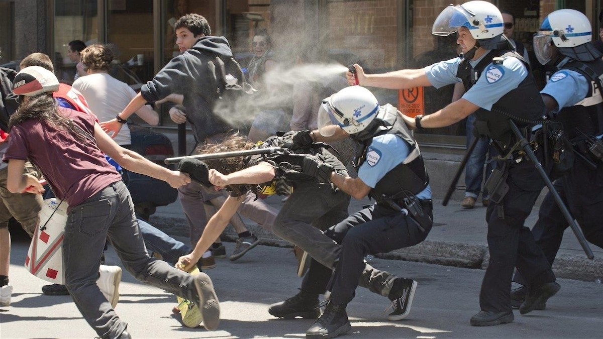 Des policiers utilisent du poivre de Cayenne lors d'une manifestation.