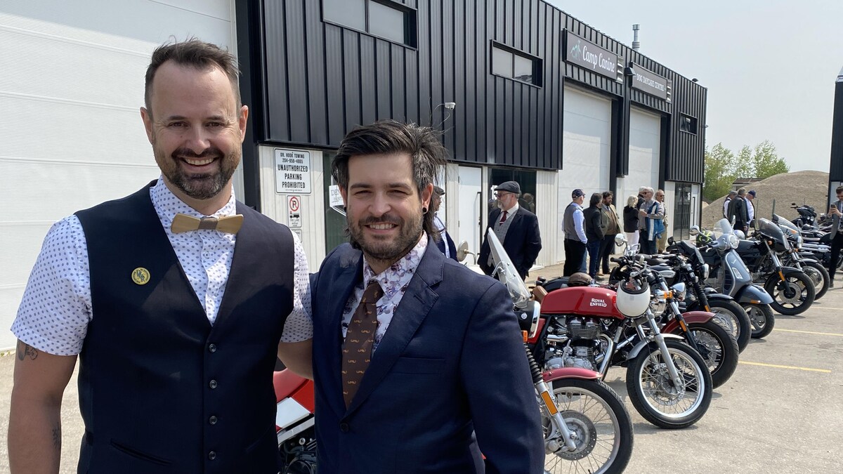 Deux personnes se tiennent debout devant une file de motos.