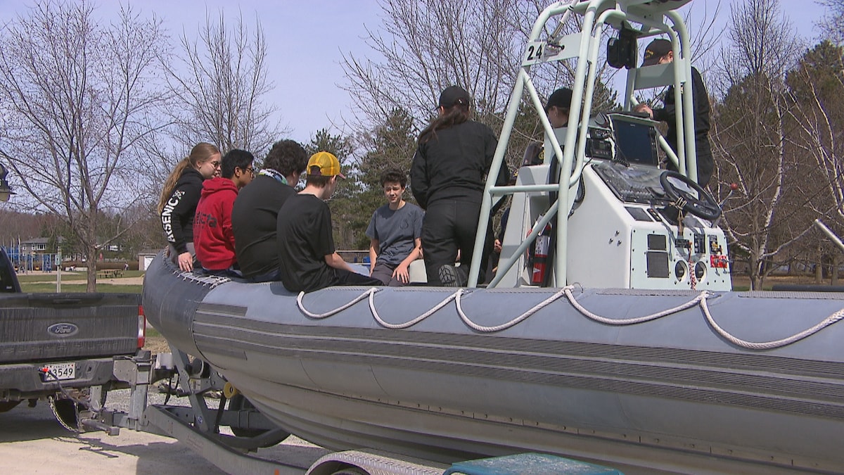 Des jeunes sont installés dans un bateau pneumatique.