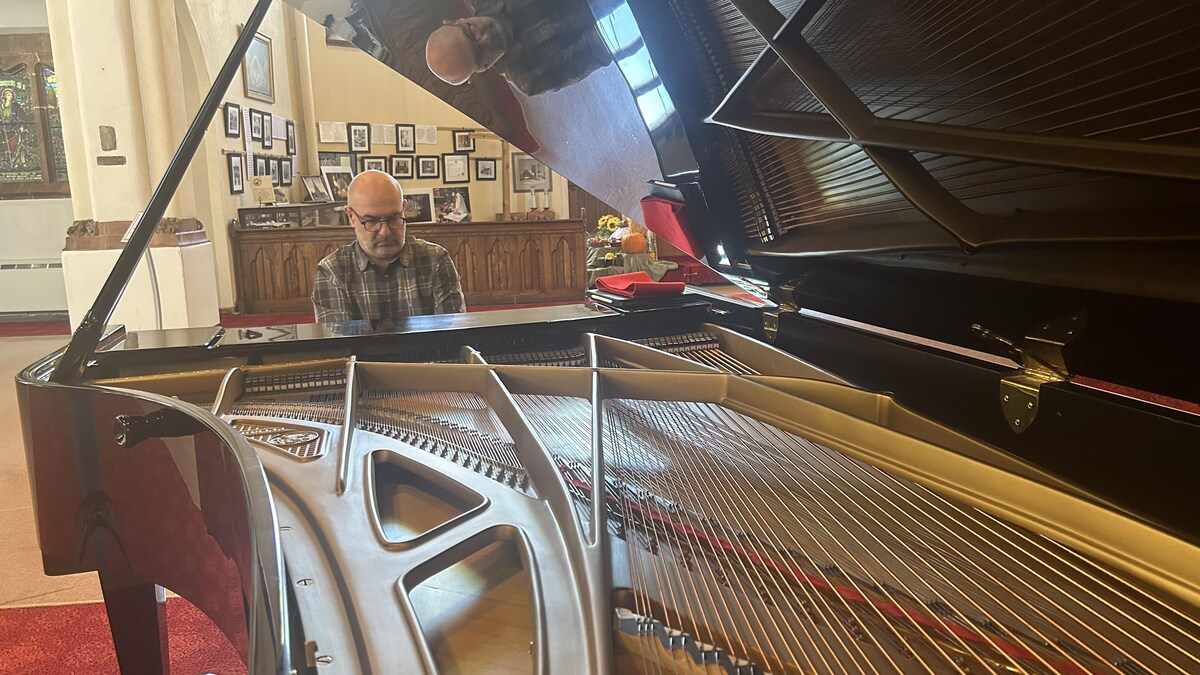 Max Midroit est assis au piano, alors que le couvert est ouvert, dans la cathédrale St. John à Saskatoon, le 7 octobre 2023. 