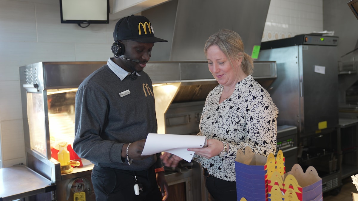 Assane Dioune et Cathy Courchesne discute dans la cuisine d'un McDonald's.