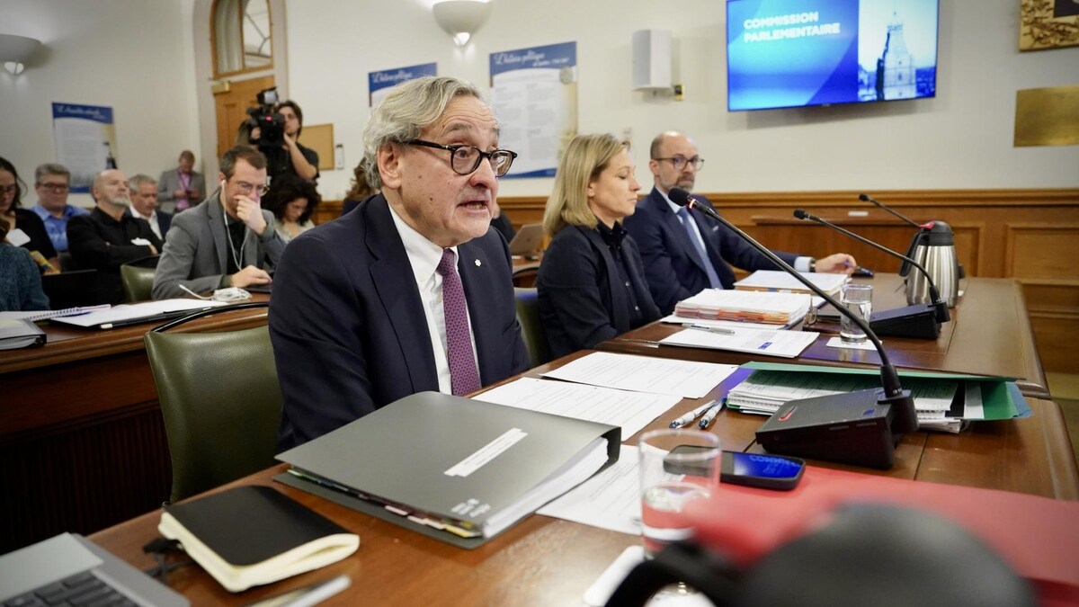 Michael Sabia est assis à une table en commission parlementaire en compagnie d'autres personnes.               
