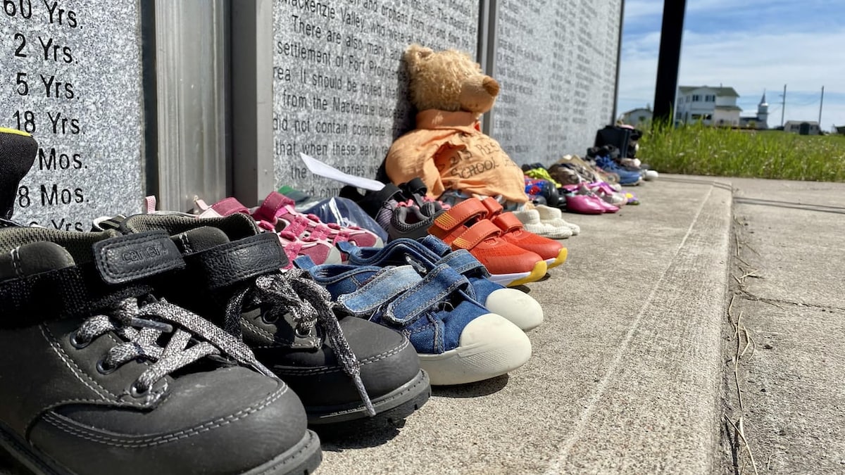 Des chaussures et un ours en peluche sont au pied du monument dédié aux enfants du pensionnat pour Autochtones à Fort Providence.