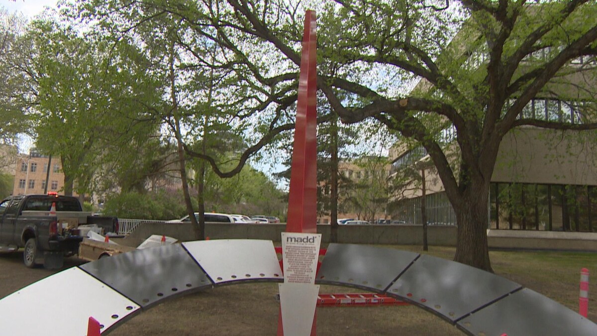 Vue du monument à la mémoire des victimes.   Une barre avec à sa base un arc de cercle en métal. Une plaque métallique au milieu porte sur laquelle est inscrit le sigle MADD suivi de la liste de 45 noms de victimes.