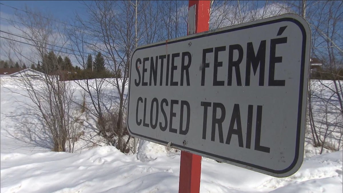 Une affiche «Sentier fermée» vue en hiver.