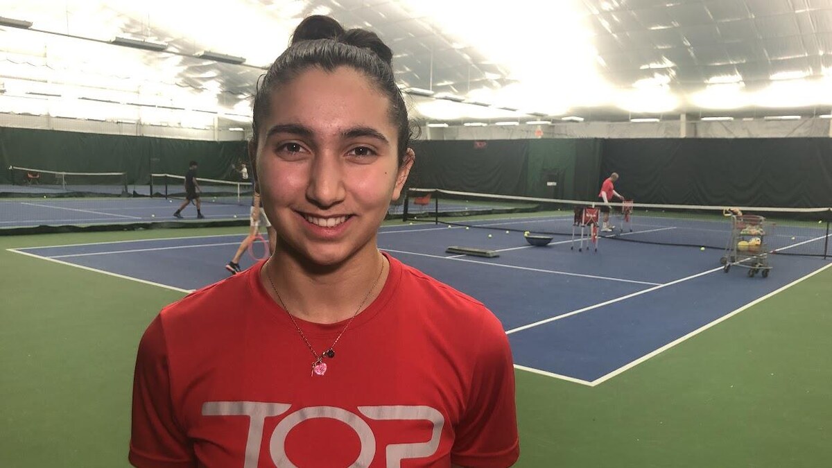Neda Rahimkhani pose pour la caméra sur un terrain de tennis.