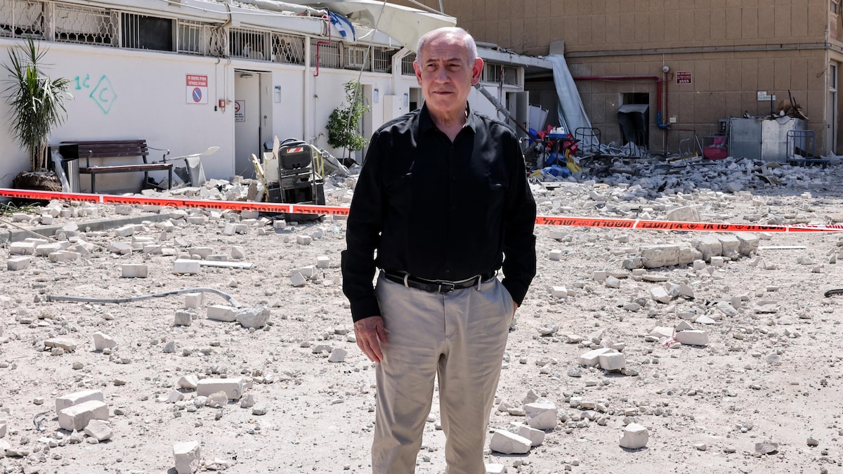 Un homme debout au milieu de débris.