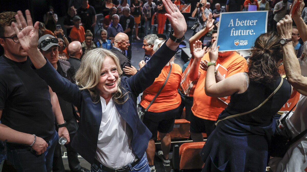 Rachel Notley salue des partisans dans une salle.