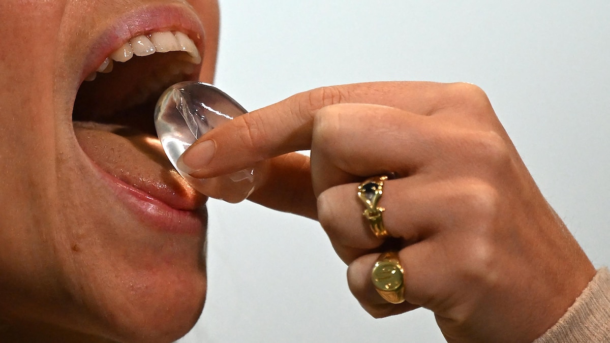 Une personne porte à sa bouche une bulle comestible.