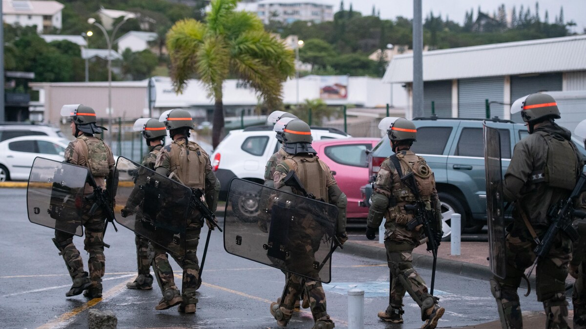Des soldats français marchent aux alentours d'un aéroport. 