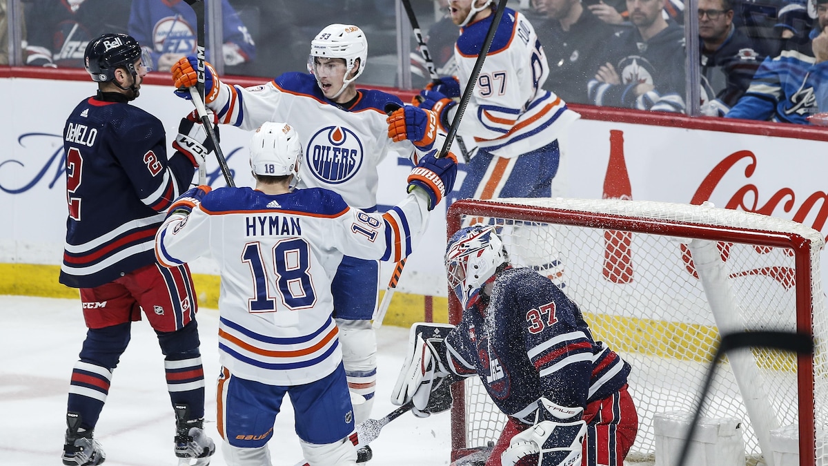 Ryan Nugent-Hopkins, Zach Hyman et Connor McDavid, des Oilers d'Edmonton, célèbrent un but contre les Jets de Winnipeg.