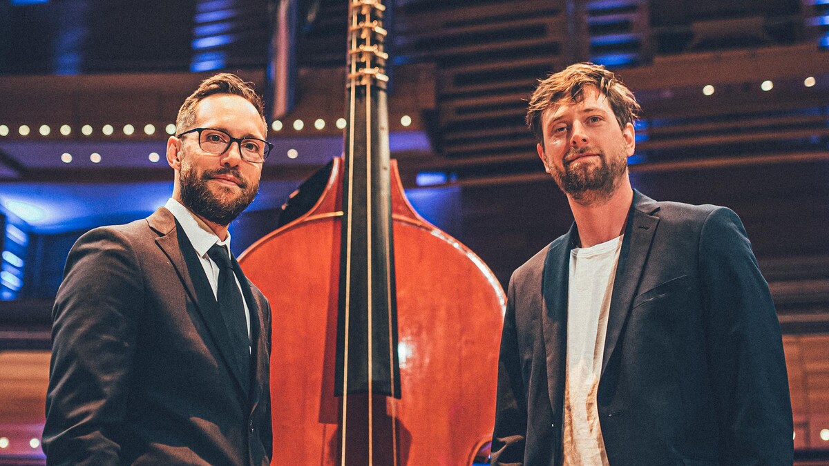 Les deux hommes se tiennent à côté d'une octobasse à la Maison symphonique de Montréal. 