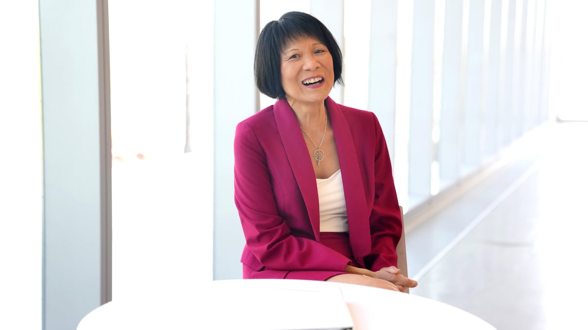 Olivia Chow sourit, assise à une table.