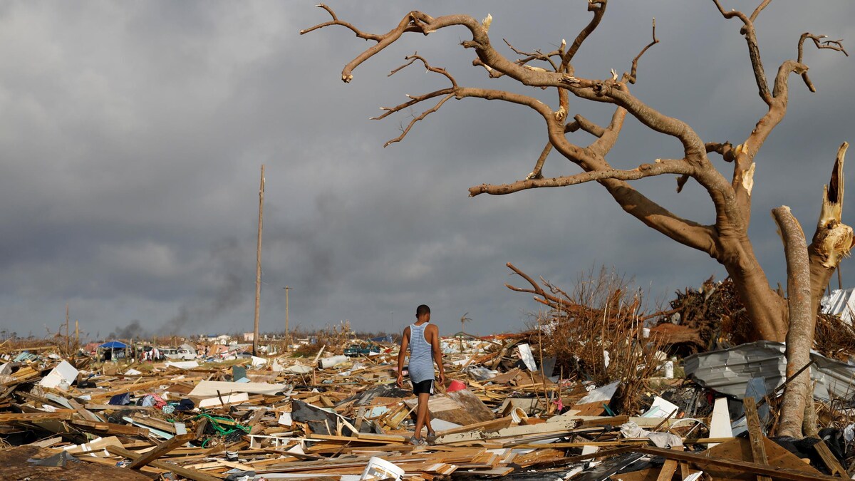 Un homme marche parmi les débris et les ruines.