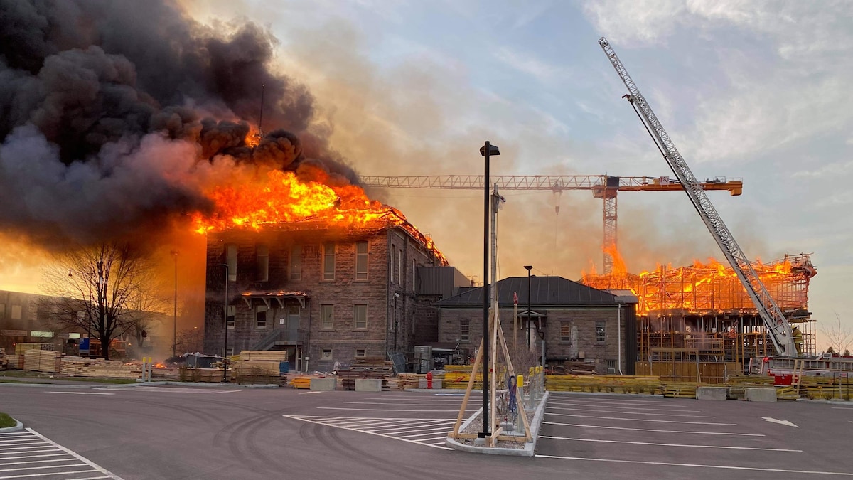 Toute la toiture d'un bâtiment en rénovation est en flammes.