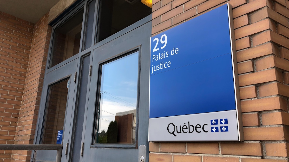 Les portes principales du palais de justice. Sur une pancarte, à l'entrée, il est écrit : 29, palais de justice, Québec.