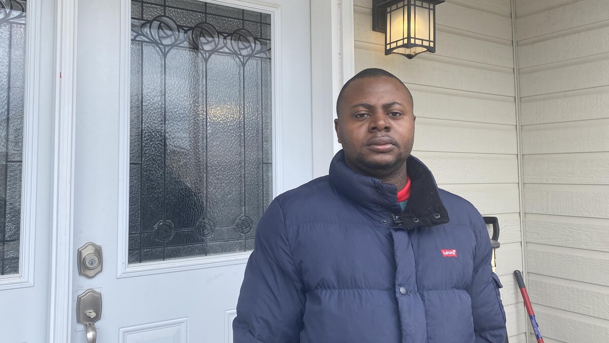 Parfait Nganso se tient devant la porte de son ancien logement, qu'il a dû quitter.