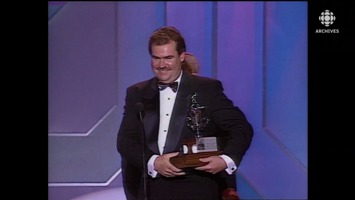 Pat Burns souriant tient son trophée.