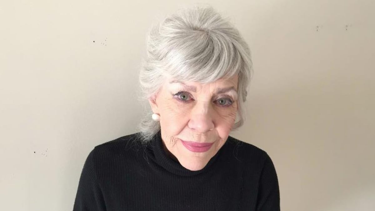 Pat Steel, cheveux blancs, vêtue de noir, regarde intensément vers la lentille de l'appareil-photo.