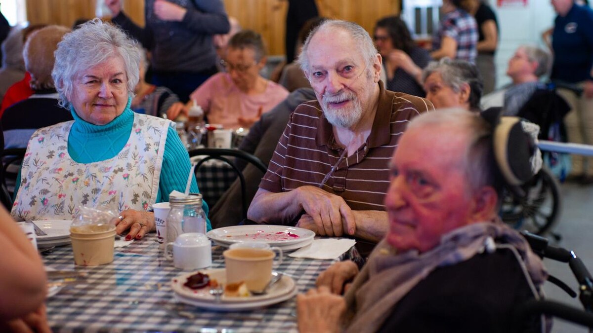 Trois aînés assis à table autour d'un repas.