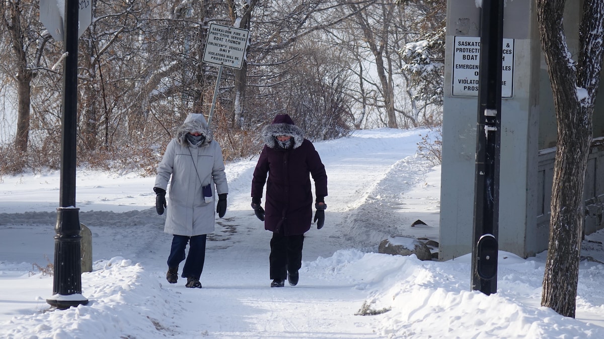 Deux personnes marchent dehors l'hiver.