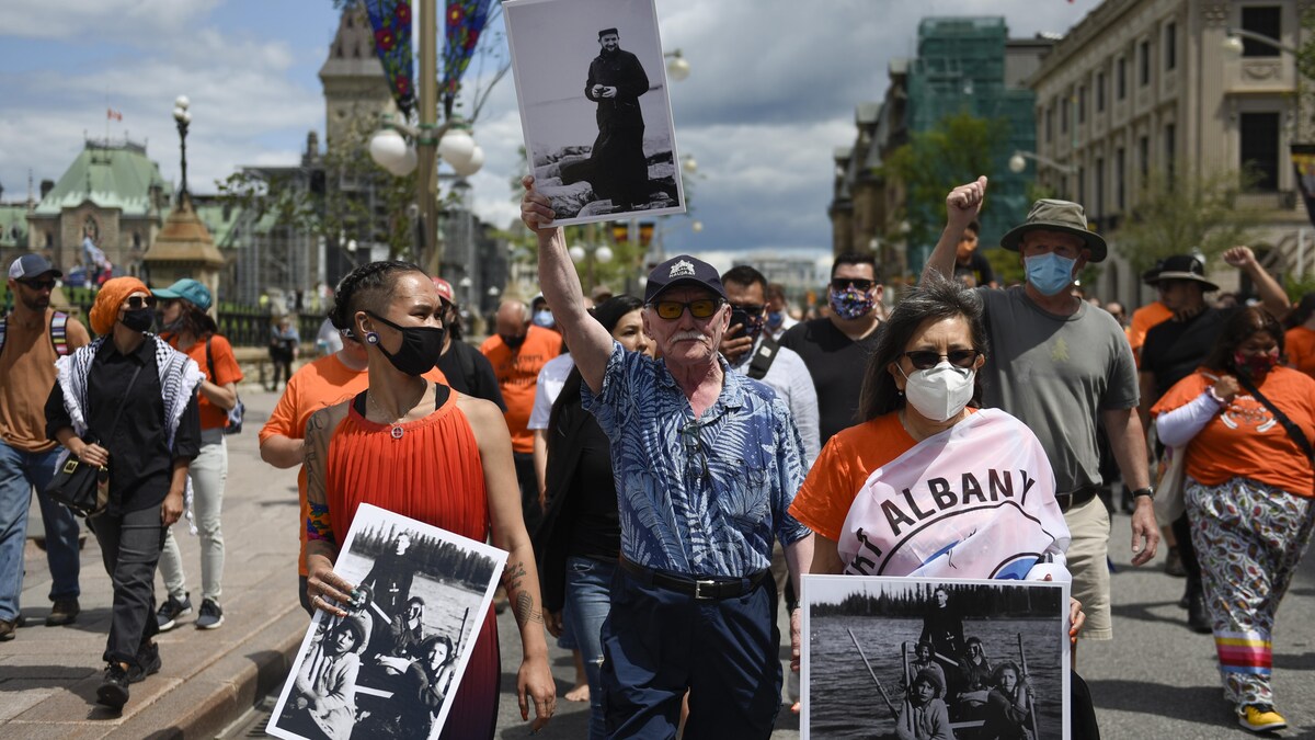 Plusieurs manifestants marchent à Ottawa pour demander une enquête indépendante sur les crimes du Canada contre les peuples autochtones.