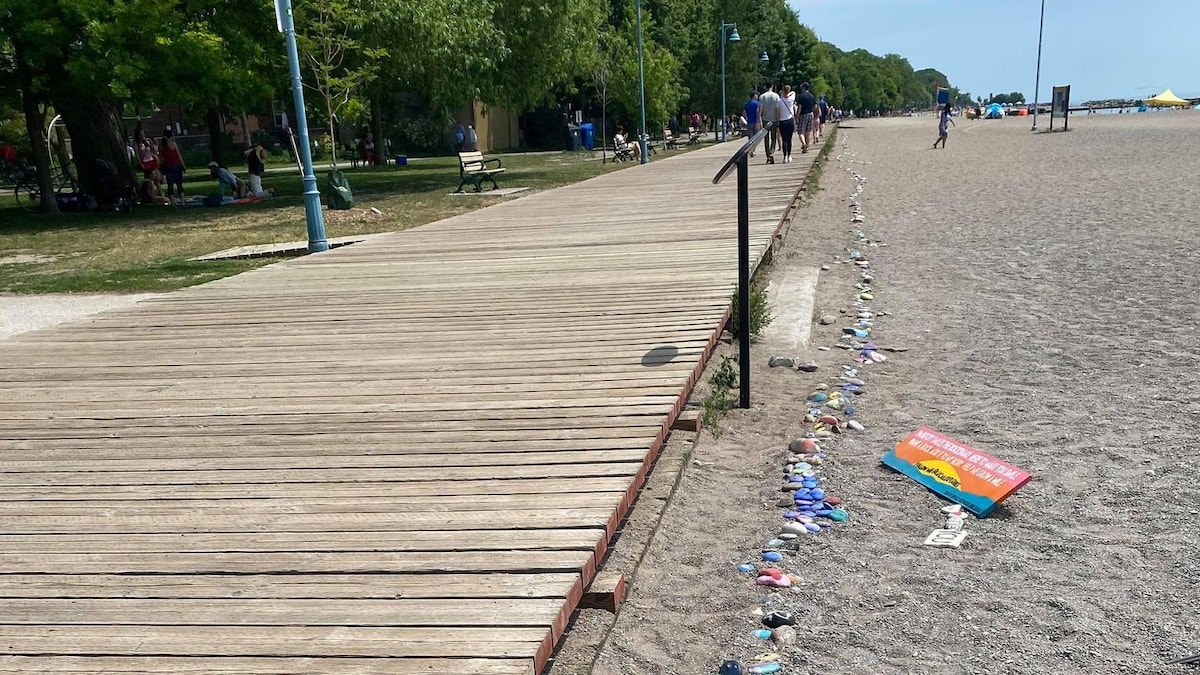 Toutes sortes de roches placées sur le sable sont alignées près de la promenade.