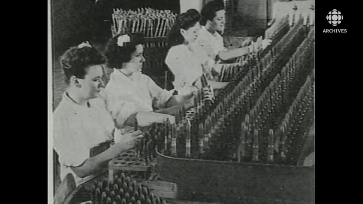 Femmes qui remplissent des cartouches dans l'usine de munitions.