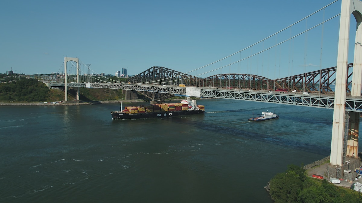 Un bateau passe sur le fleuve sous le pont Pierre-Laporte, lien principal entre Québec et Lévis.