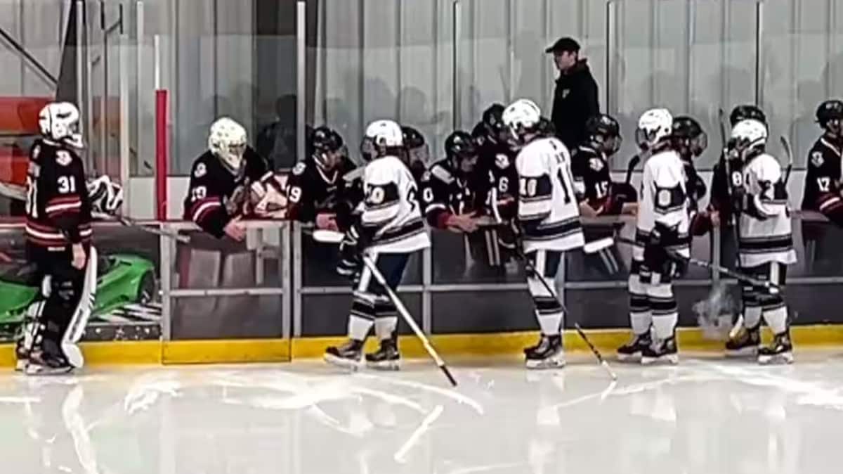 De jeunes joueurs de hockey se donnent la main. 