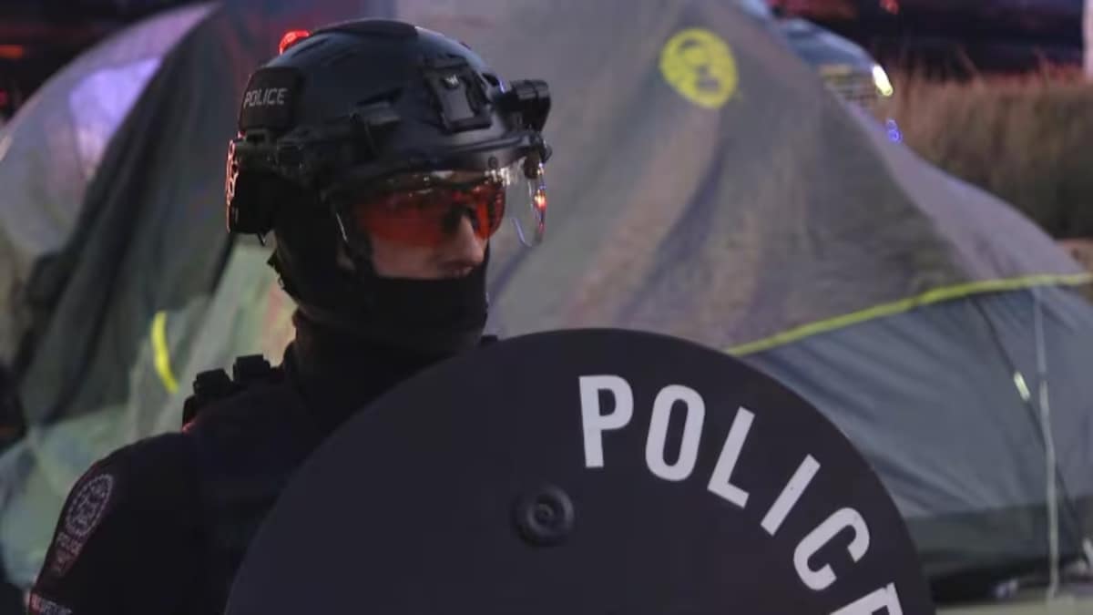 Un policier équipé dun bouclier et portant un masque anti-émeute, à Calgary, le 9 mai 2024.