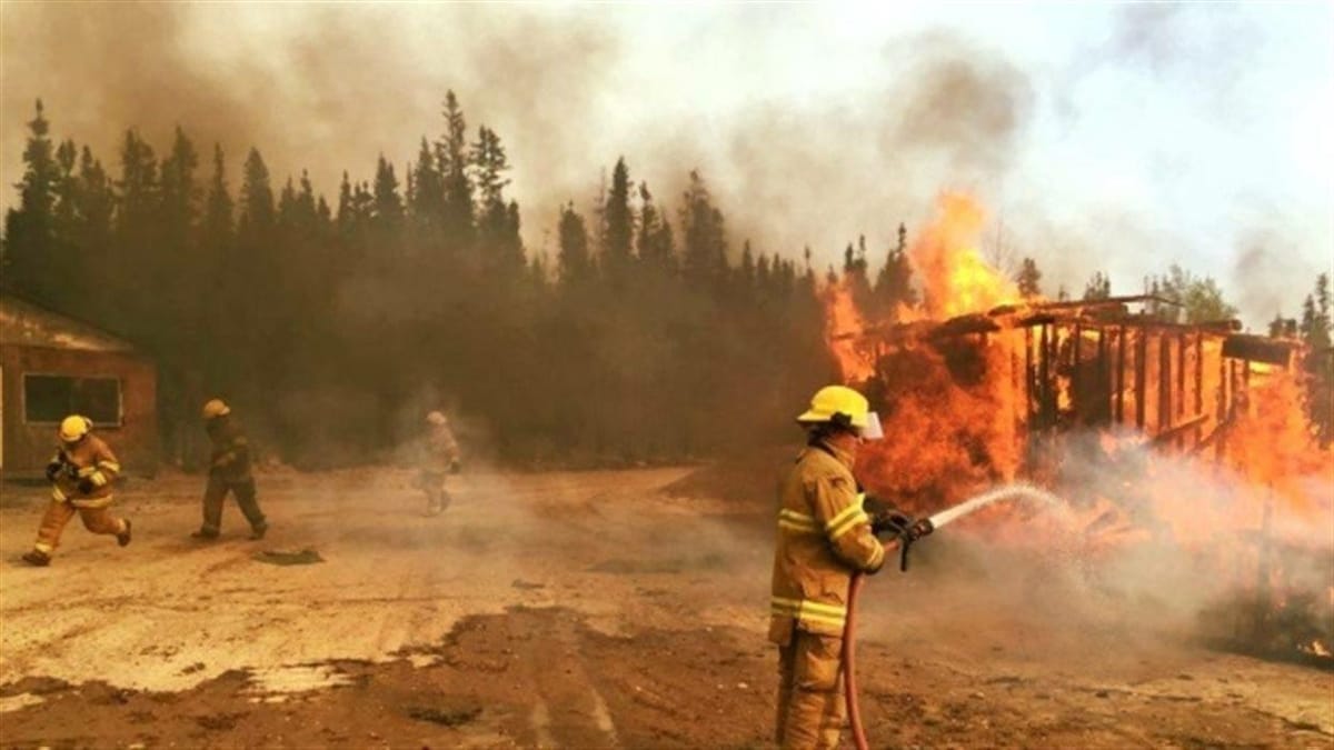 Des pompiers combattant l'énorme feu de forêt qui a ravagé la ville de Fort McMurray en Alberta en mai 2016.